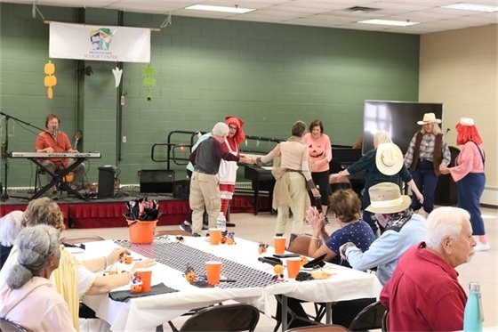 Senior Center members dance and socialize as someone plays the keyboard