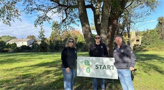Committeewoman Kimberly Kratz, Mayor Tony Perry, and Deputy Mayor Rick Hibell stand in front of the Mayor's Challenge sign at the Mayor's Challenge